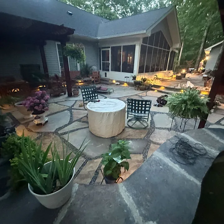 Custom-designed paver patio with built-in seating and fire pit surrounded by flowers