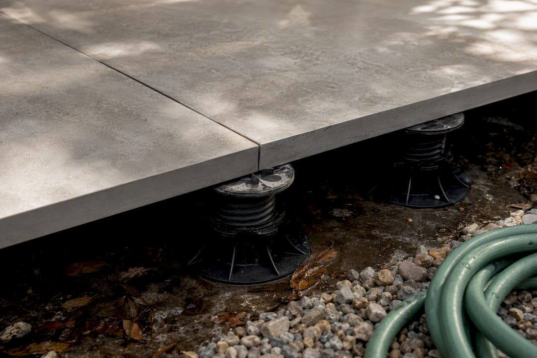 Raised pedestal patio slabs with drainage gaps below