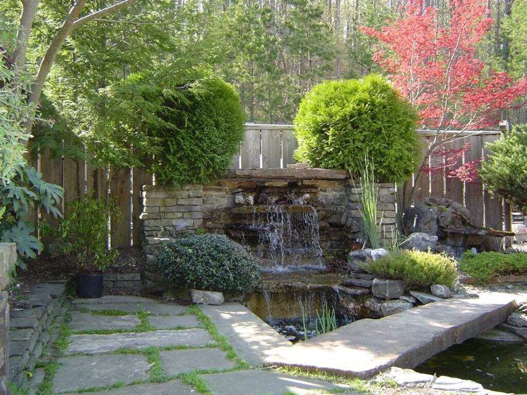 Backyard waterfall and pond, stone slab bridge, flagstone edge