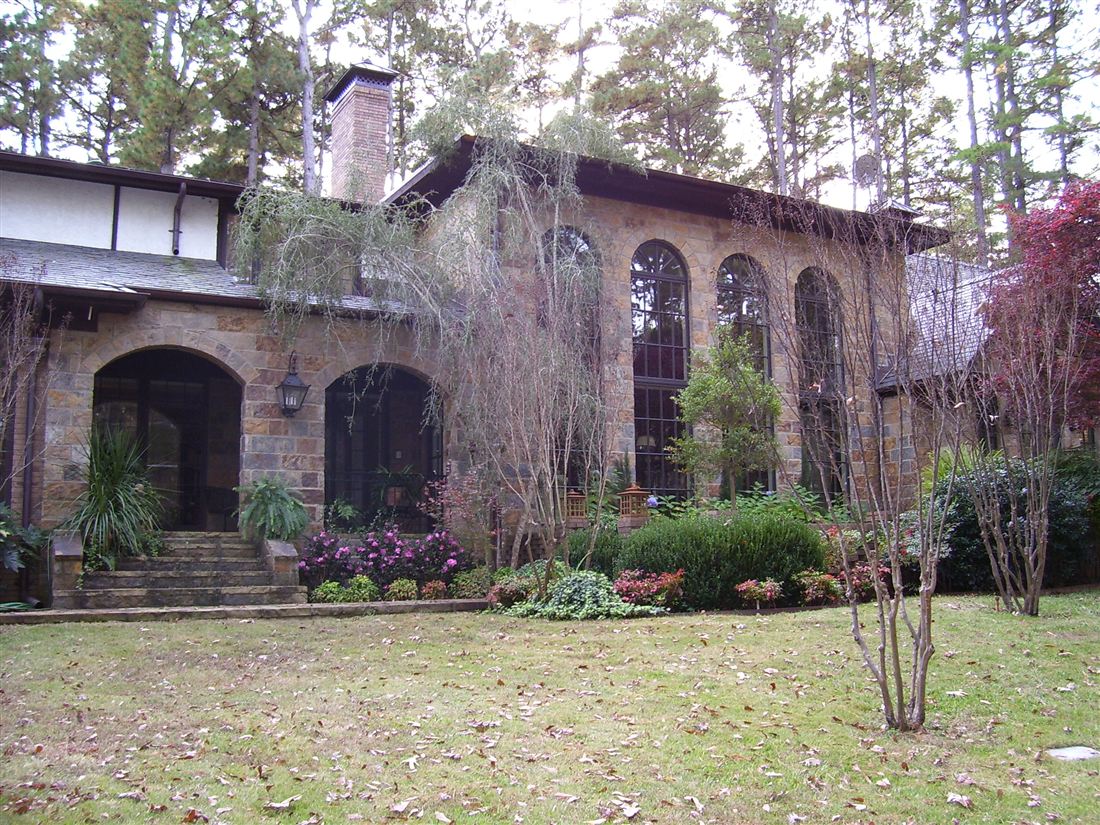 Chopped-stone Tudor, arched loggia and courtyard