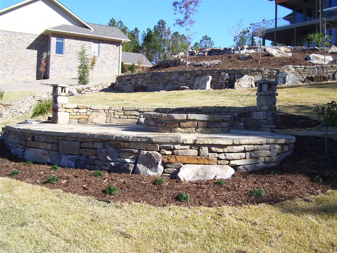 Curved seat wall, stone columns at the patio