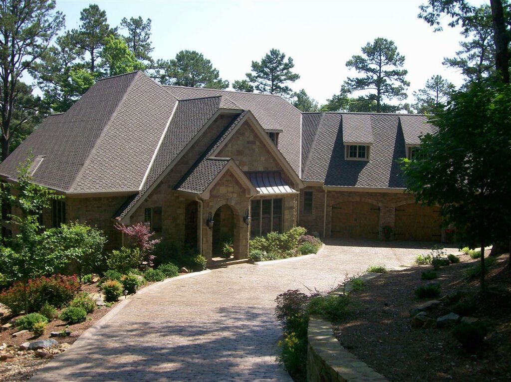 Cut-limestone French country, paver drive and stone walls