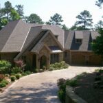 Cut-limestone French country, paver drive and stone walls