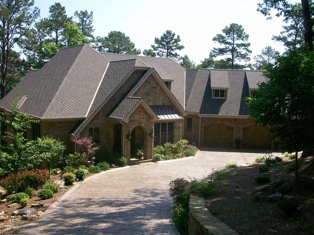 Cut-limestone French country, paver drive and stone walls