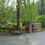 Entry columns and iron gate, with a planted island