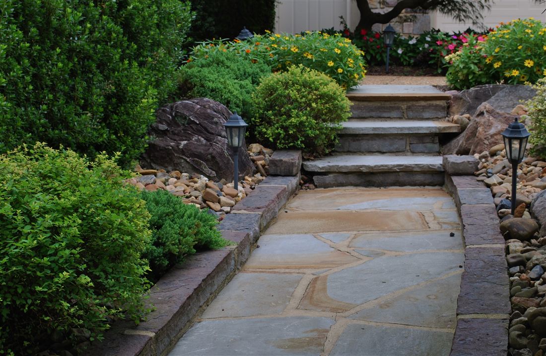 Flagstone steps and path, set among boulders and creek rock, with low-voltage lanterns
