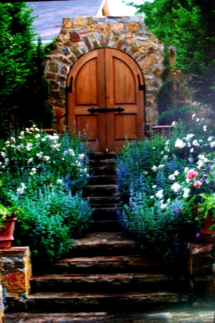 Garden gate, arched wood door in a stone wall