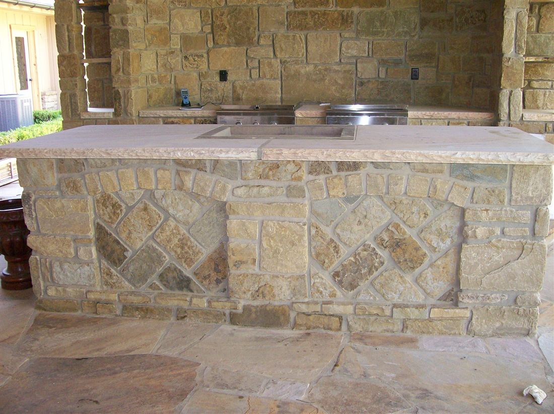 Outdoor kitchen island, limestone base, slab top