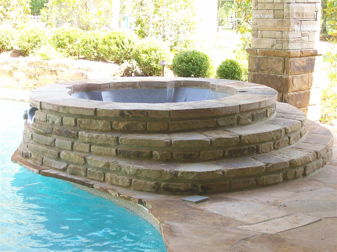 Raised spa, stepped stone base with spillover