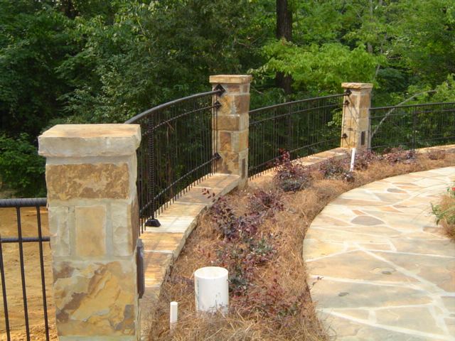Stone columns, iron fence at the pool