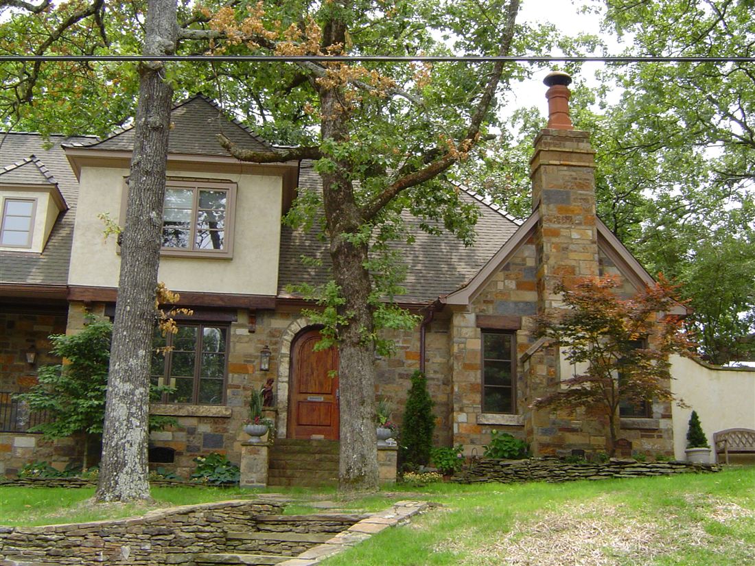 Stone cottage, chimneys and arched door