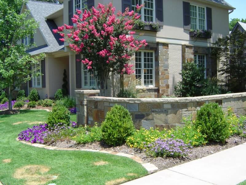 Stone house, crepe myrtle and stone wall